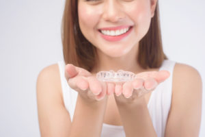 young smiling woman holding invisalign braces over 2022 01 19 22 49 09 utc